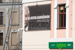 Baner z prezesem Kaczyńskim przy pomniku jego brata
